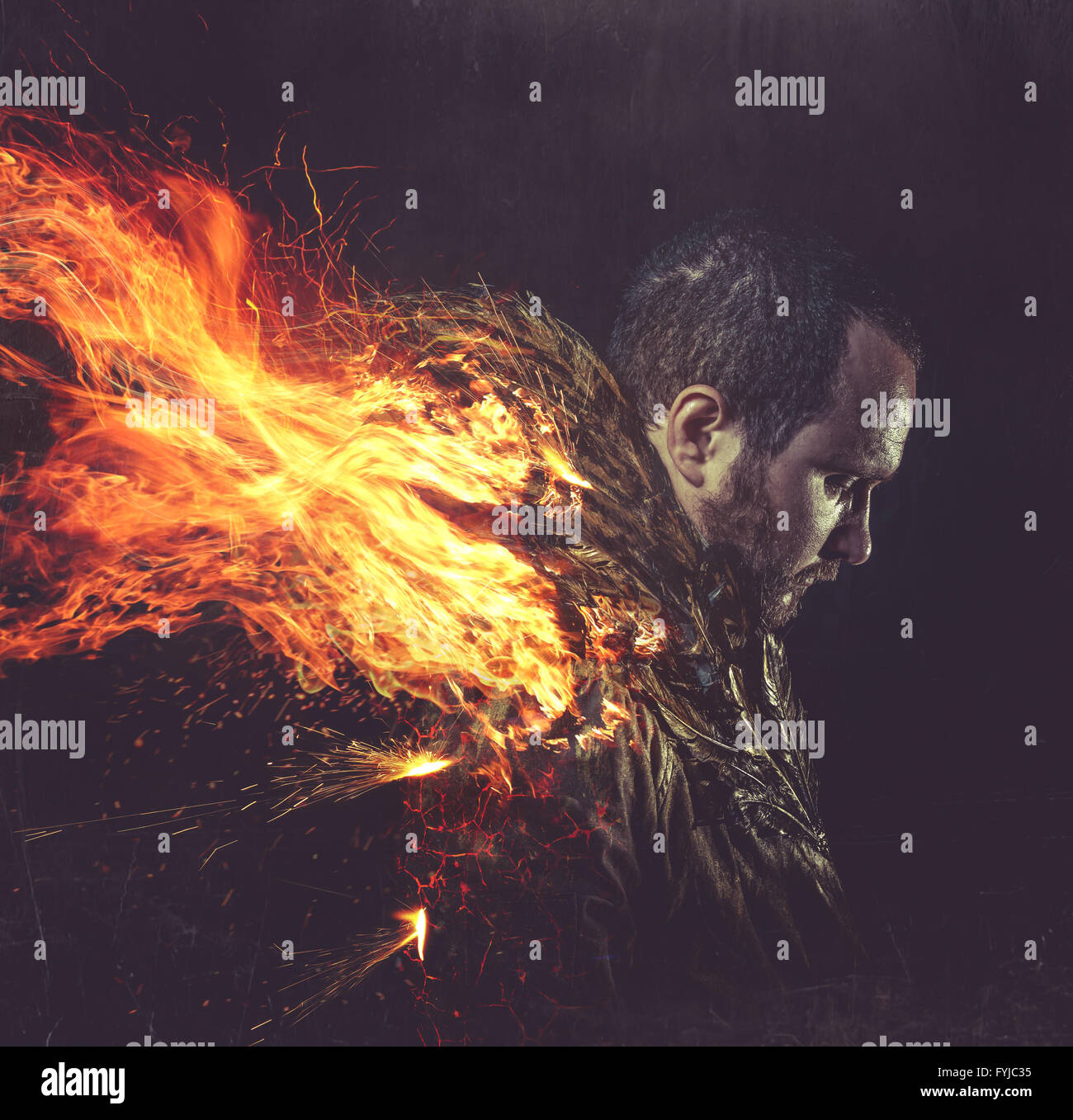gefallener Engel, Jacke Mann mit goldenen Federn auf den Flügeln und Feuer Stockfoto