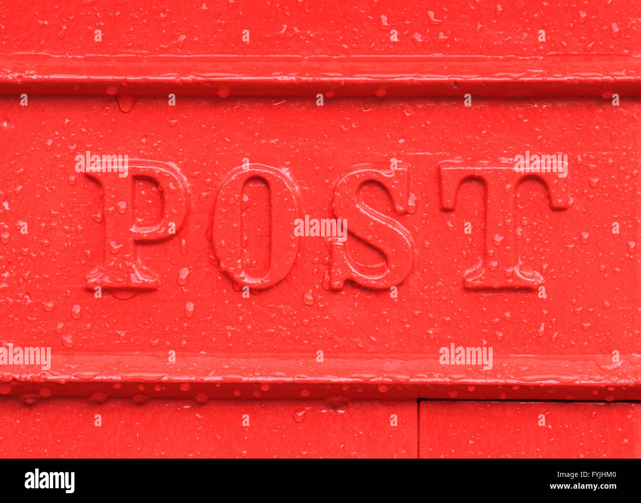 Alte englische roten Briefkasten Detail im Regen Wassertropfen und das Wort Post zeigen. Stockfoto