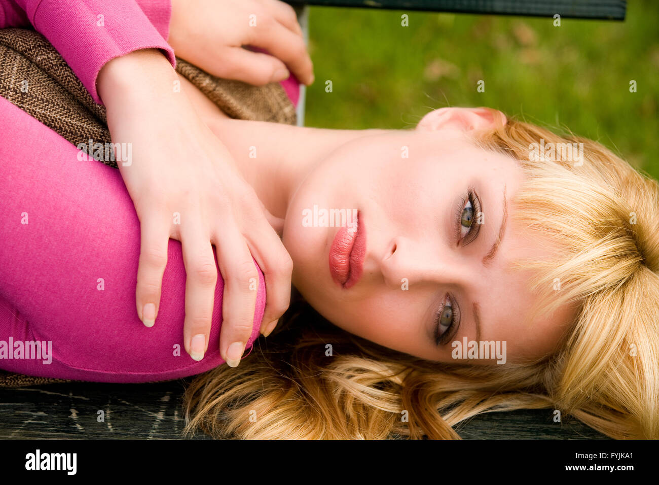 Süße blonde Mädchen auf einer Bank Stockfoto