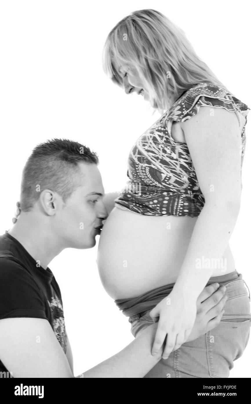 Den Bauch seiner schwangeren Freundin küssen Stockfoto