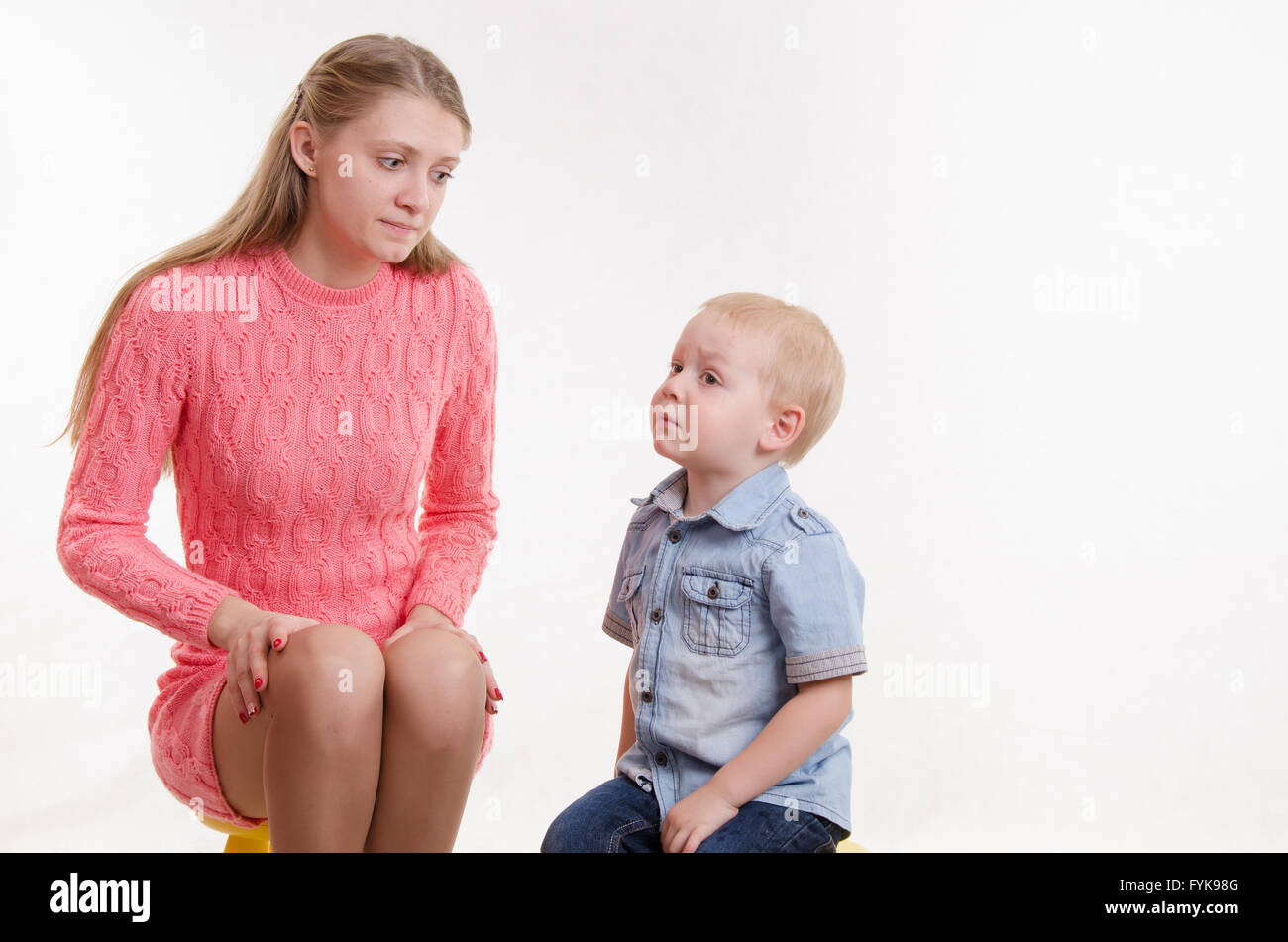 Junge Mutter schaut vorwurfsvoll seinen jungen Sohn Stockfoto