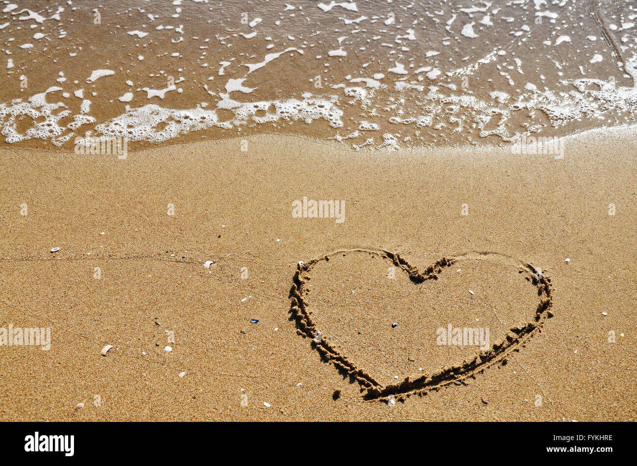 Herzen auf dem Sand des Strandes gezeichnet Stockfoto