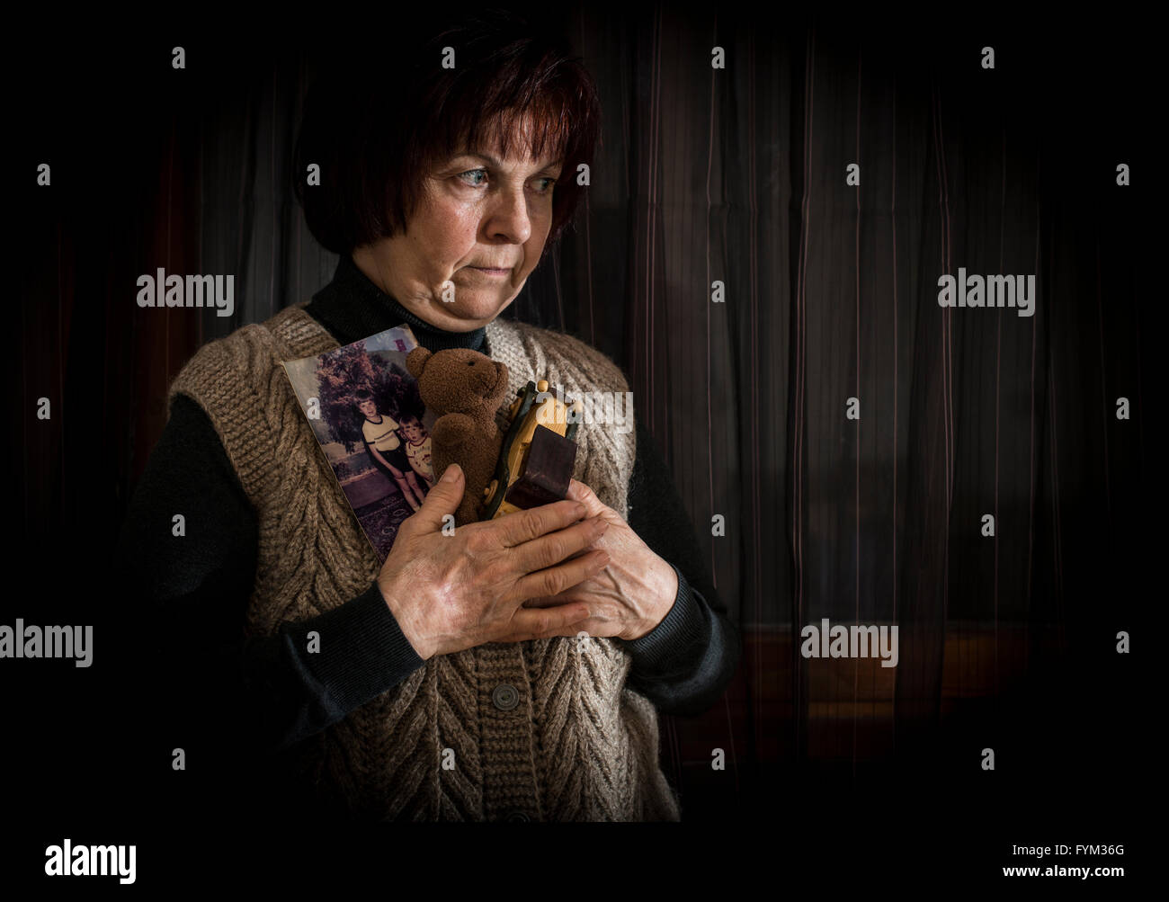 Ältere Frau halten Bilder der Kinder. Spielzeug Stockfoto