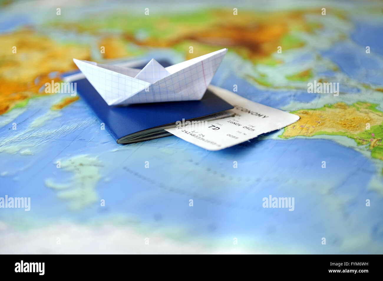 Papierschiff, Pass auf einer Hintergrundkarte der Welt. Reisen-Konzept Stockfoto