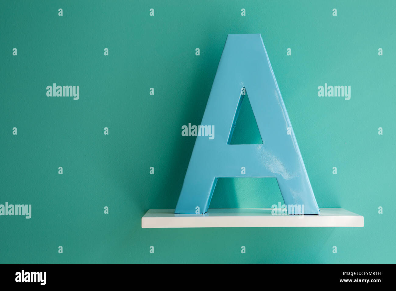 Schreiben Sie eine türkis-blaue Farbe auf einem weißen Regal. Stockfoto