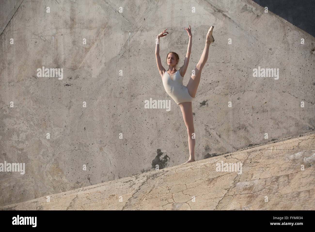 Schlanke Tänzerin sitzt in einer Ballett-pose Stockfoto