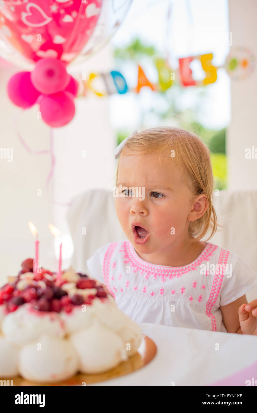 Kleines Mädchen bläst Kerzen auf ihrem Geburtstagskuchen Stockfoto