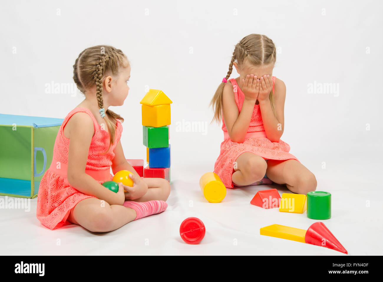 Mädchen verletzt ein anderes Mädchen spielen mit Spielzeug Stockfoto