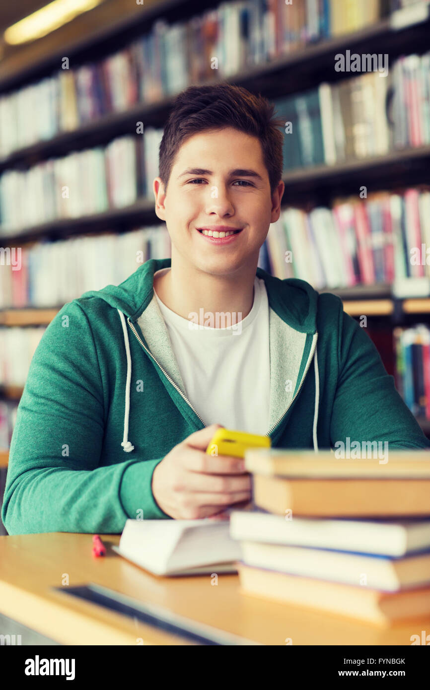 männliche Studenten mit Smartphone und Bücher in der Bibliothek Stockfoto