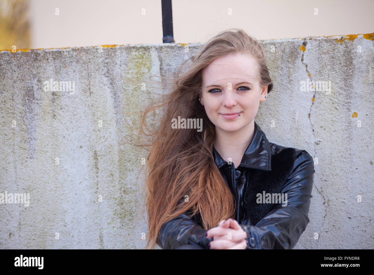 Eine Frau mit langen Wind geblasen rotes Haar draußen zu sitzen. Stockfoto