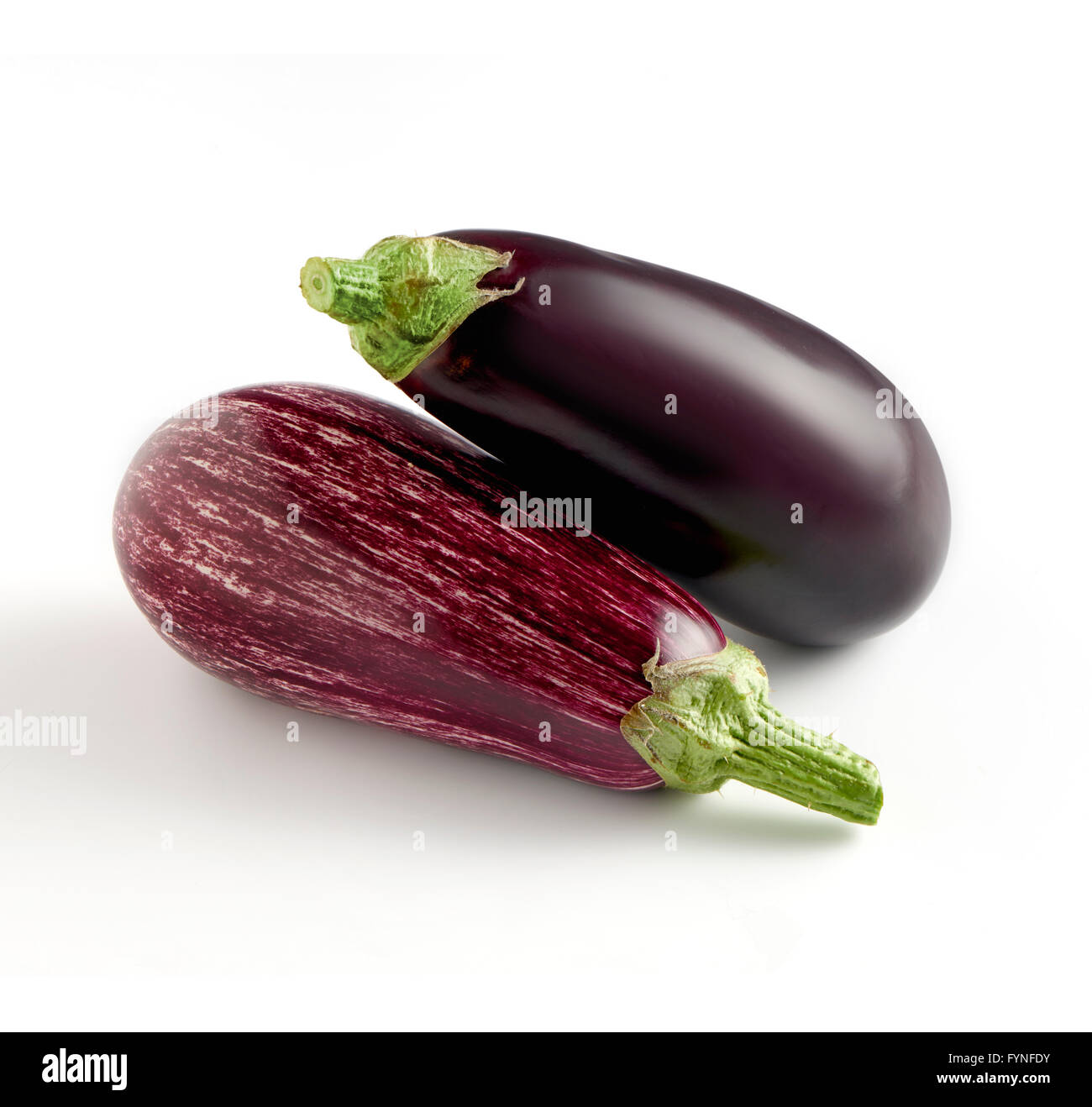 Zwei ganze Frische Auberginen Sorten auf normalen solid violett und ein Graffiti mit weissen Abzeichen, nebeneinander auf einem weißen backgr Stockfoto