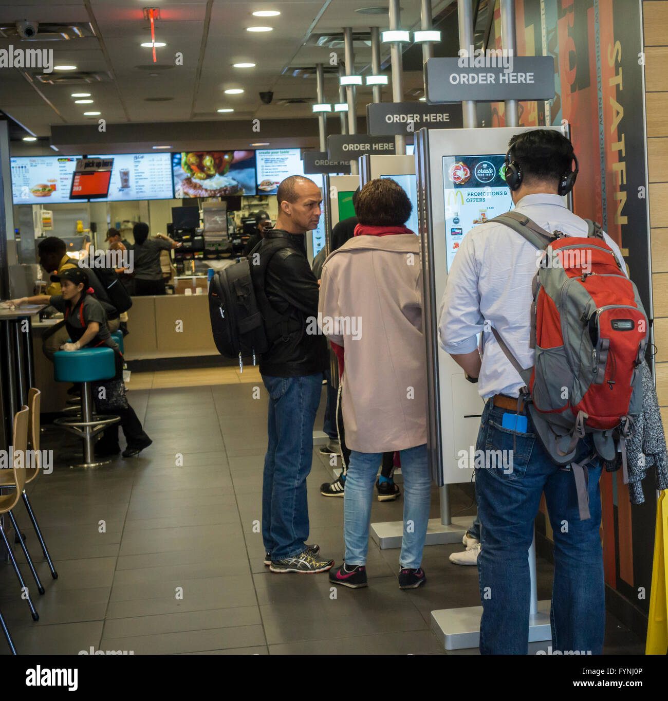 American Diner Bestellung auf "Erstellen Sie Ihren Geschmack" Kioske bei McDonalds am Dienstag, 26. April 2016 in New York. Die interaktive iPad-ähnliche Digitalanzeigen erlauben es Kunden, ihre Bestellung mit Belag, neue Soßen usw. anpassen. Die McDonald's Corp. berichtete kürzlich eine 35 % Zunahme der Gewinne, die direkt auf ihre "All Day Breakfast" Förderung zurückgeführt werden. . (© Richard B. Levine) Stockfoto