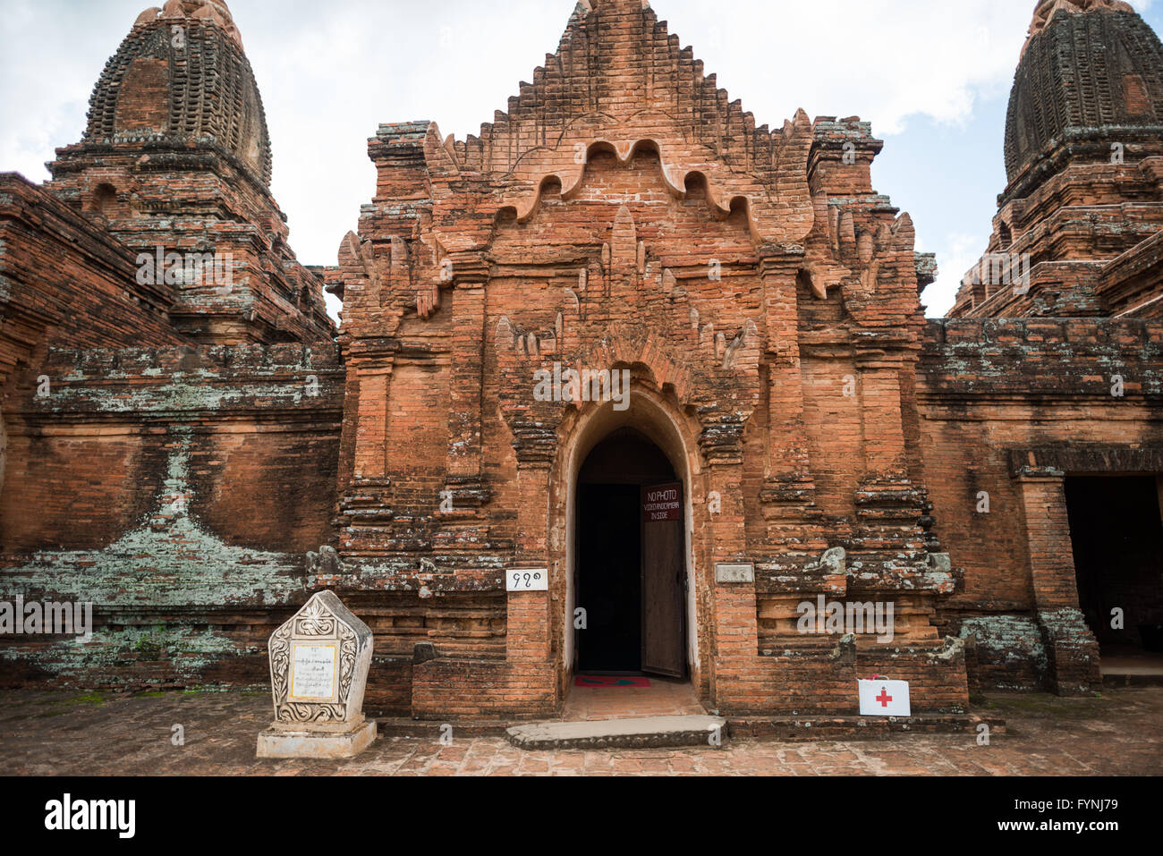 Payathonzu Tempelfassade Bagan Myanmar // BAGAN, Myanmar — die verzierte Fassade eines der drei miteinander verbundenen Tempel, aus denen der Payathonzu Tempelkomplex besteht, zeigt nach Jahrhunderten der Exposition verwitterte rote Backsteingebäude. Das Payathonzu (auch bekannt als Paya-thone-zu), das Ende des 13. Jahrhunderts erbaut wurde, ist das einzige bekannte Beispiel für drei miteinander verbundene Schrein-Strukturen in Bagans archäologischer Zone. Der Komplex wurde vor seiner Fertigstellung aus unbekannten Gründen aufgegeben, die wahrscheinlich mit dem politischen Umbruch des späten 13. Jahrhunderts zusammenhängen. Die Tempel enthalten außergewöhnliche Wandmalereien Th Stockfoto