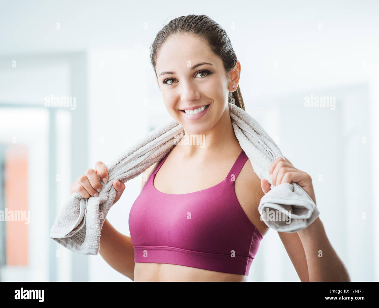 Schöne sportliche Frau mit Handtuch entspannen, im Fitnessstudio trainieren, gesunde Lebensweise und Fitness-Konzept Stockfoto