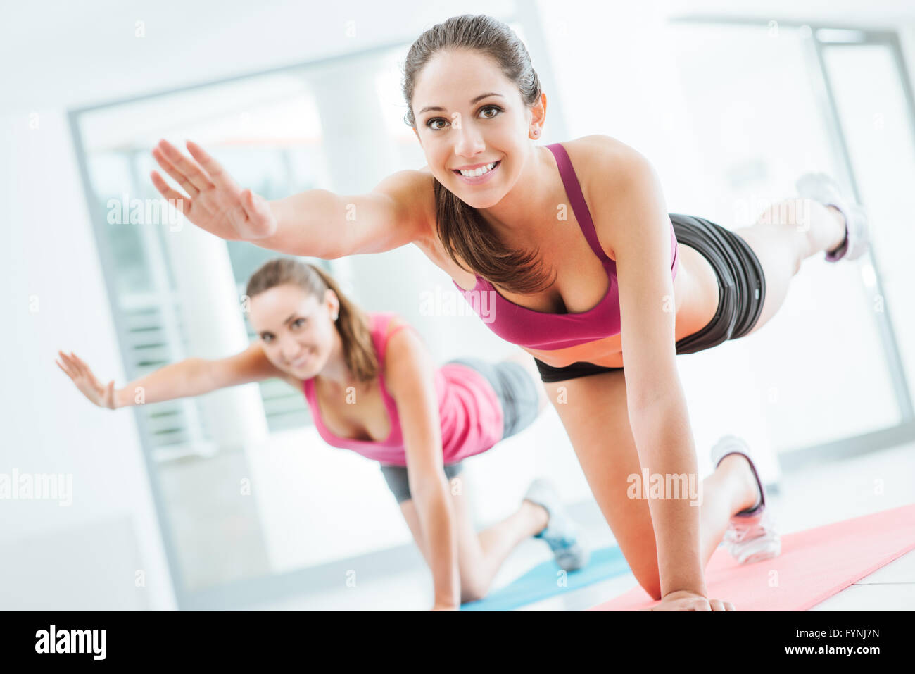 Sportliche junge Frauen in der Turnhalle dabei Pilates Training auf einer Matte, Fitness und gesunden Lifestyle-Konzept Stockfoto