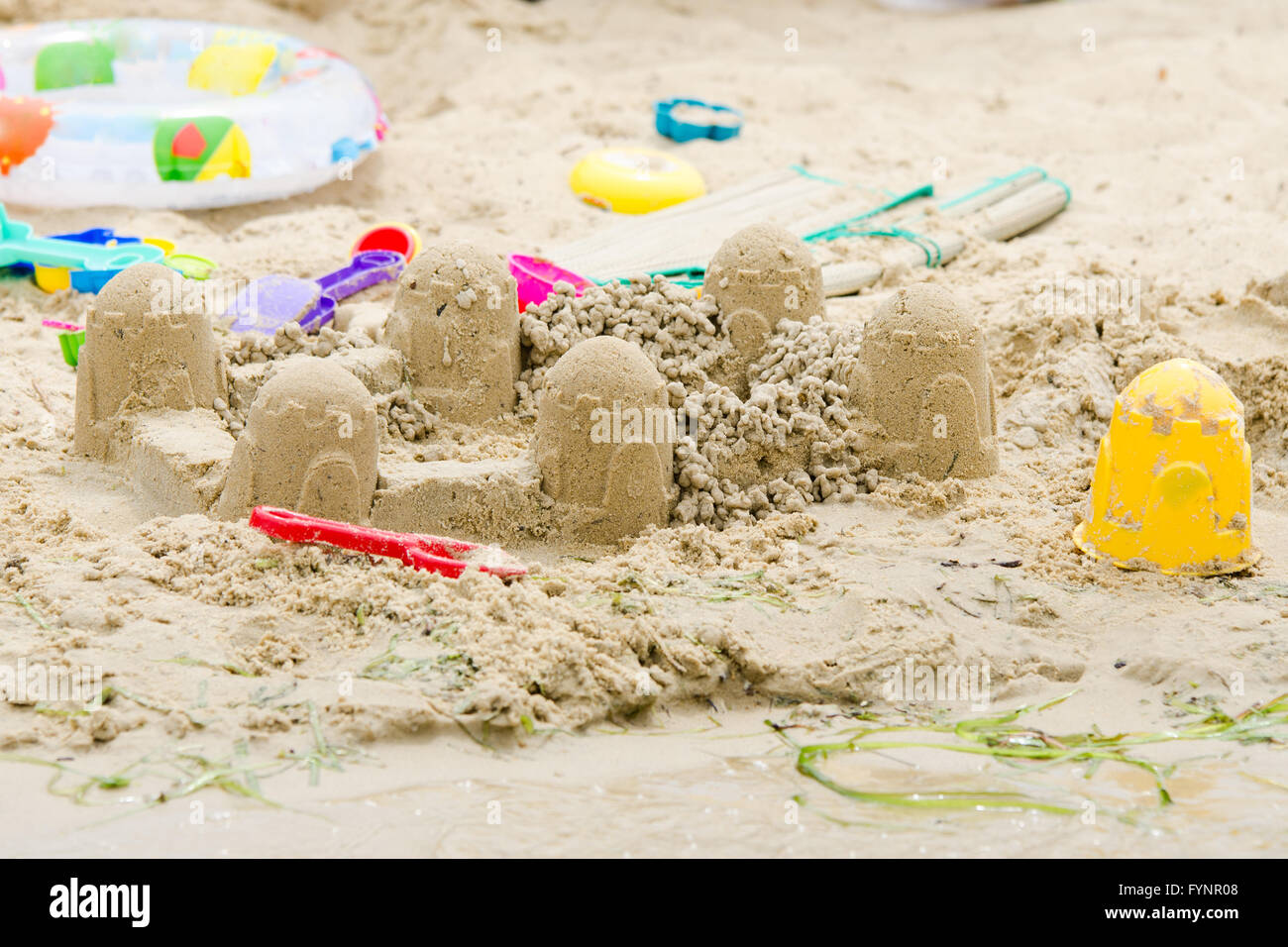 Sandburg Kreis und Spielzeug am Ufer Flusses Stockfoto