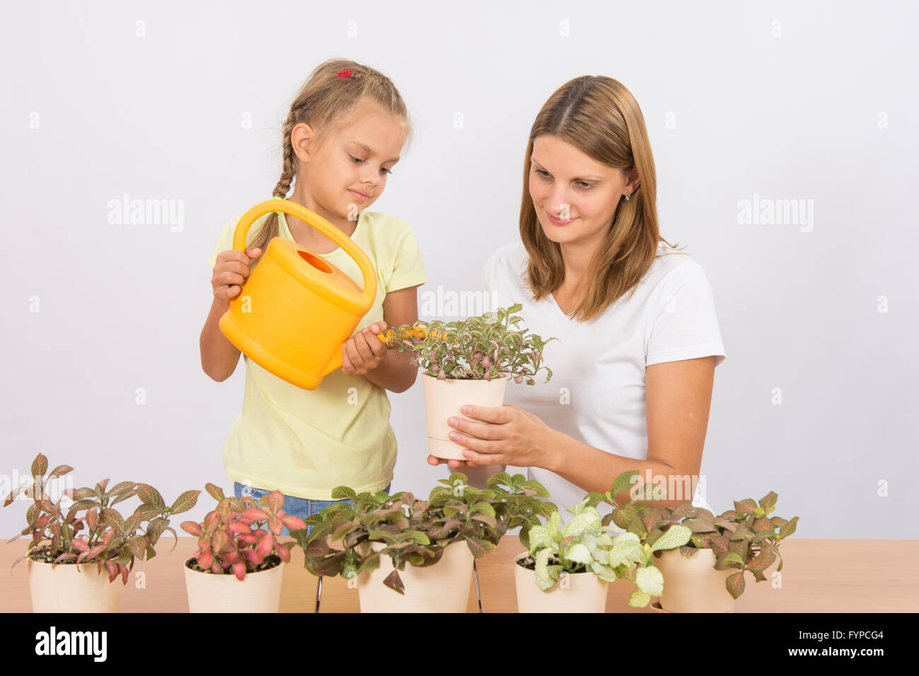 Mutter und Tochter, die Bewässerung von Topfpflanzen Stockfoto