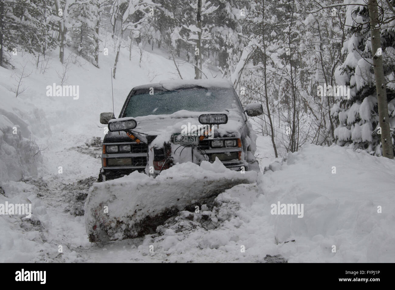 Ein LKW mit Schneepflug auf einer Bergstraße im Schnee. Stockfoto