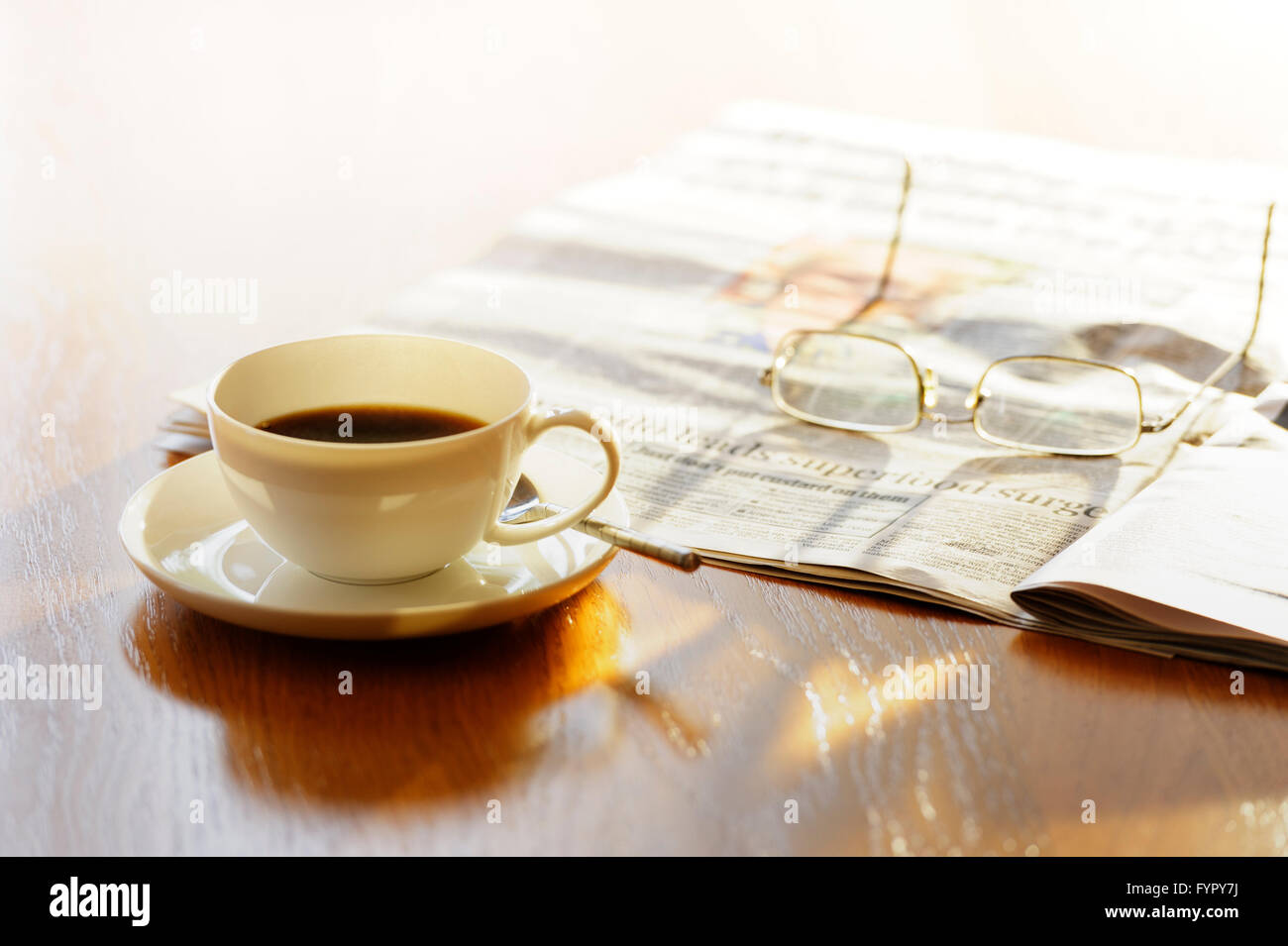 Tasse Kaffee, mit Zeitungspapier und Gläser, auf einem sonnigen Morgen. Stockfoto