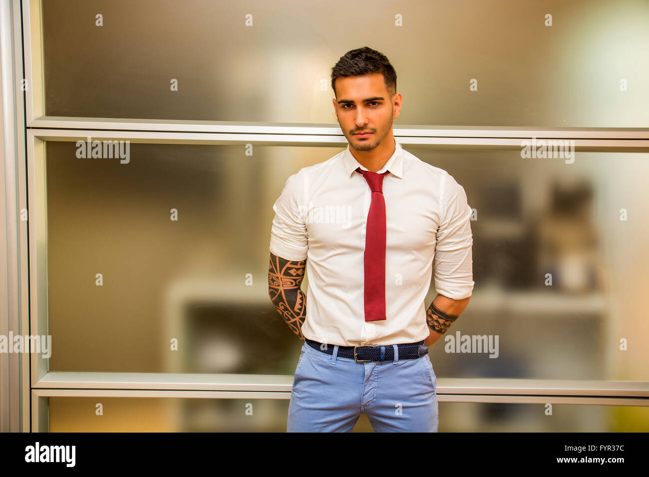 Hübscher Junge männliche Arbeiter in seinem Büro stehen, Blick in die Kamera. Alternative Look mit Tattoos auf den Armen Stockfoto