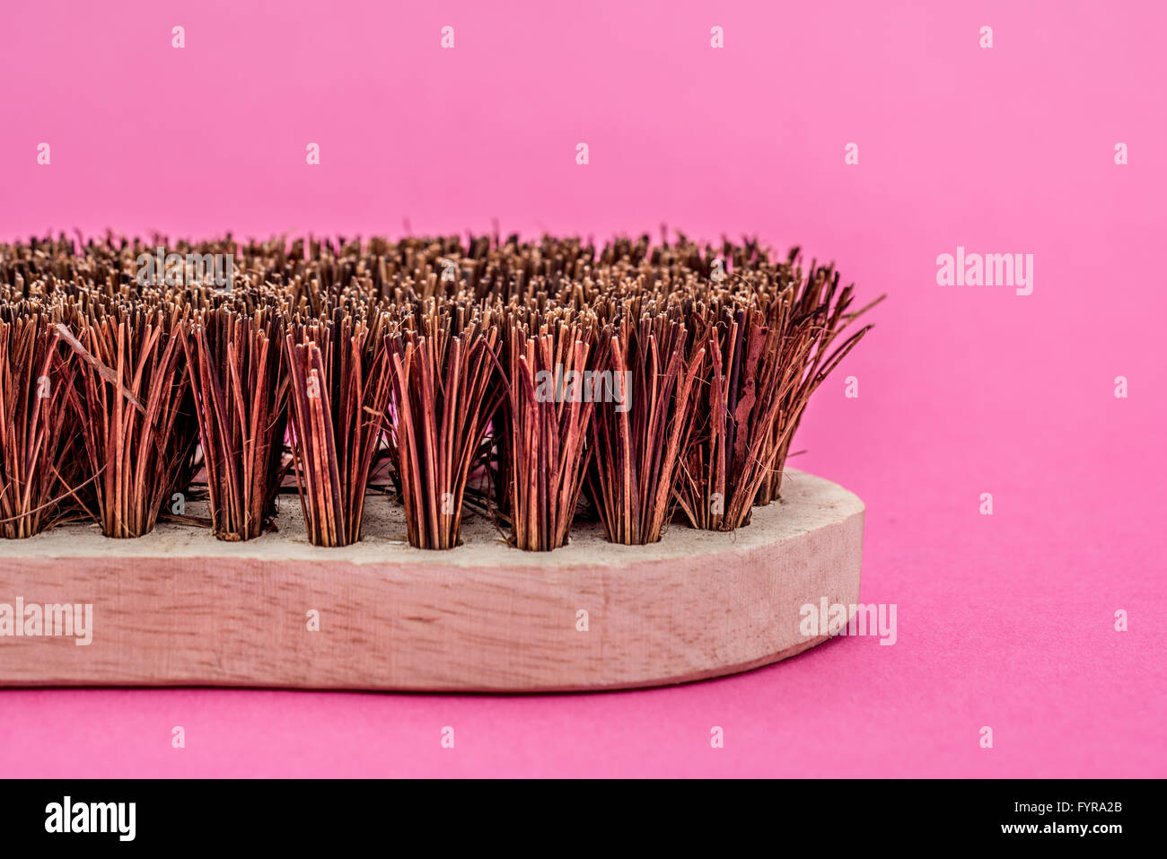 Traditionelle hölzerne Scheuerbürste auf rosa Hintergrund Stockfoto