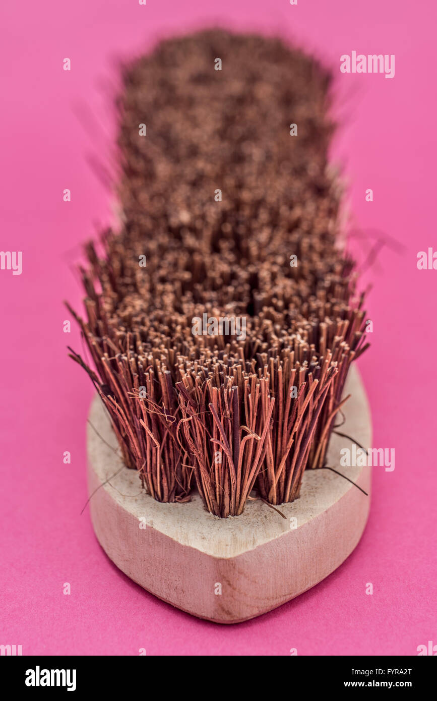 Traditionelle hölzerne Scheuerbürste auf rosa Hintergrund Stockfoto