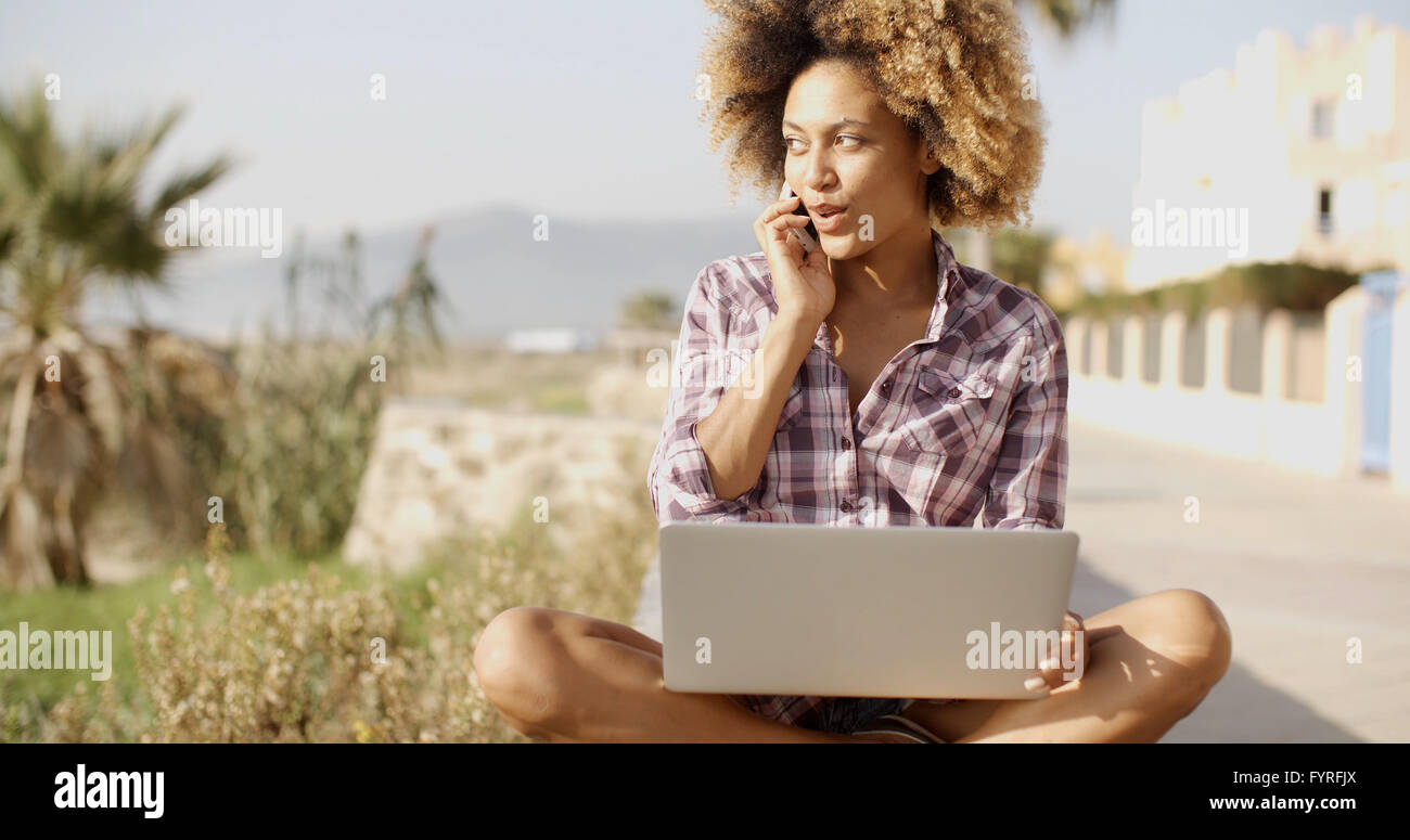 Junge afrikanische Frau arbeiten am Laptop In der Natur. Stockfoto