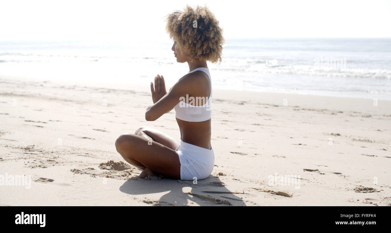 Frau-Meditation am Strand Stockfoto