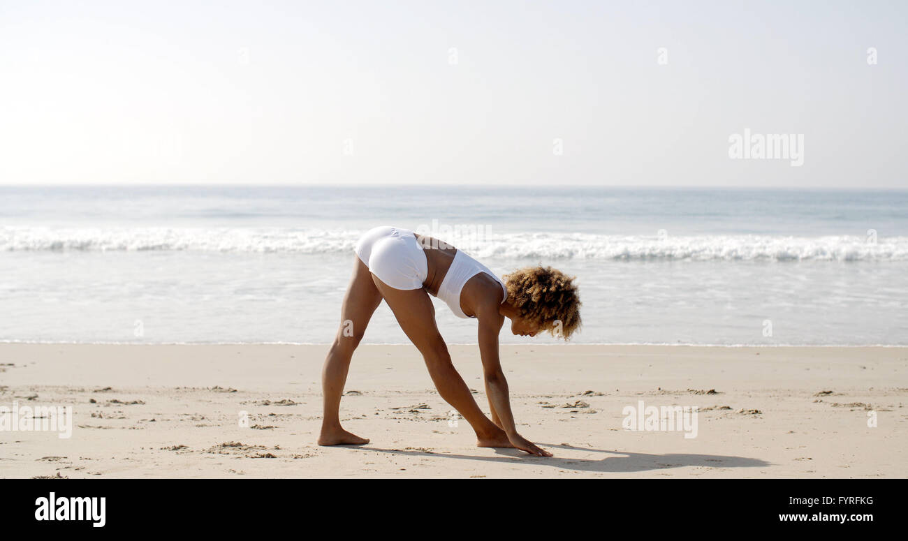 Frau praktizieren Yoga am Meer Stockfoto