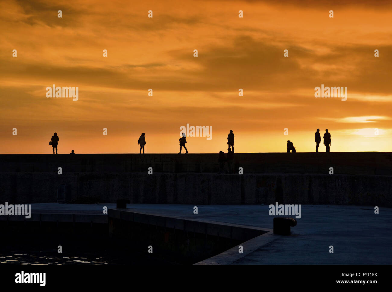 Menschen-Silhouetten Spaziergang bei Sonnenuntergang. Stockfoto