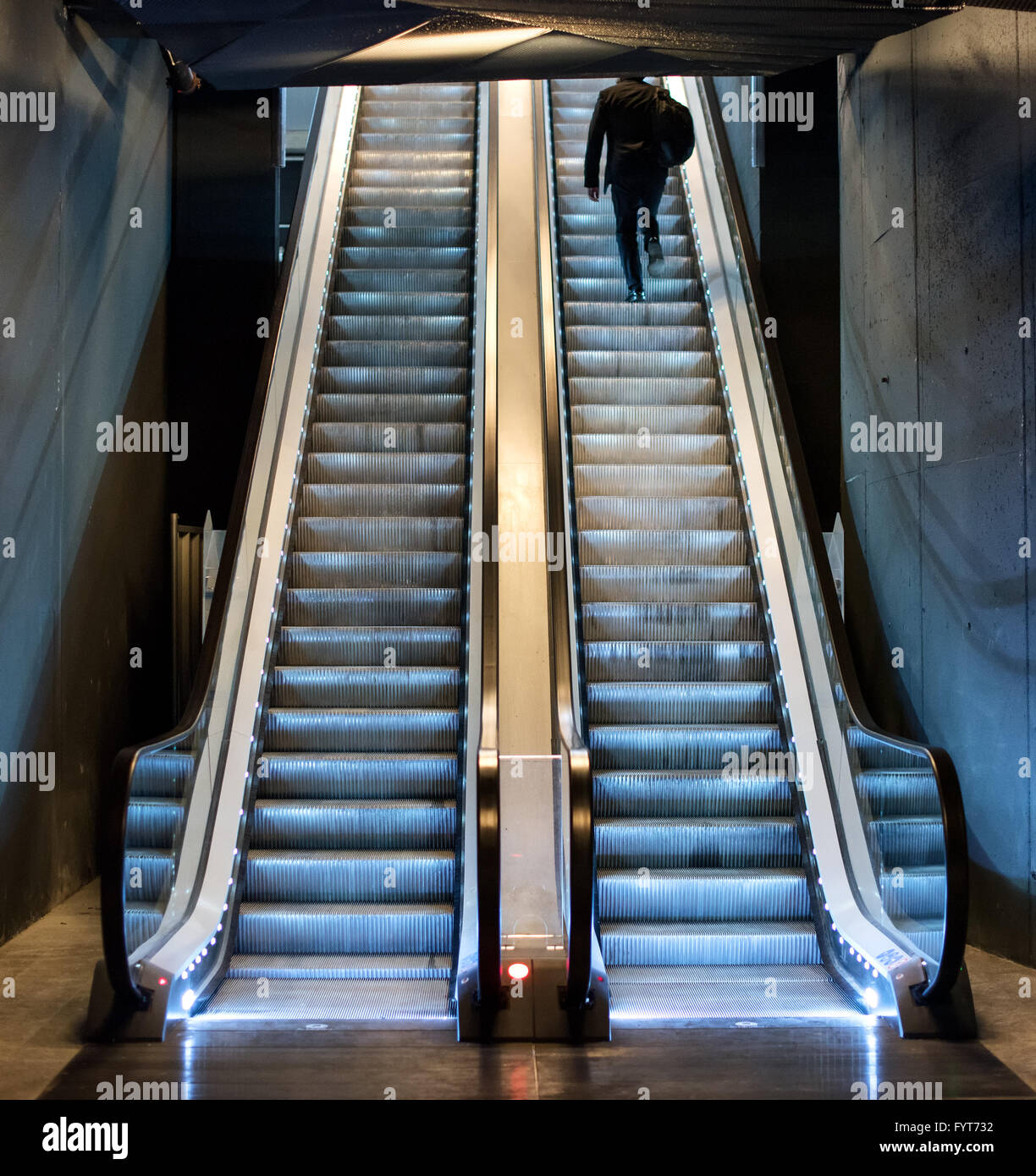 Mann, aufsteigend, die Rolltreppe von einer u-Bahn fahren auf die Bewegung in Richtung Tageslicht an die Spitze tritt, Ansicht von unten Stockfoto