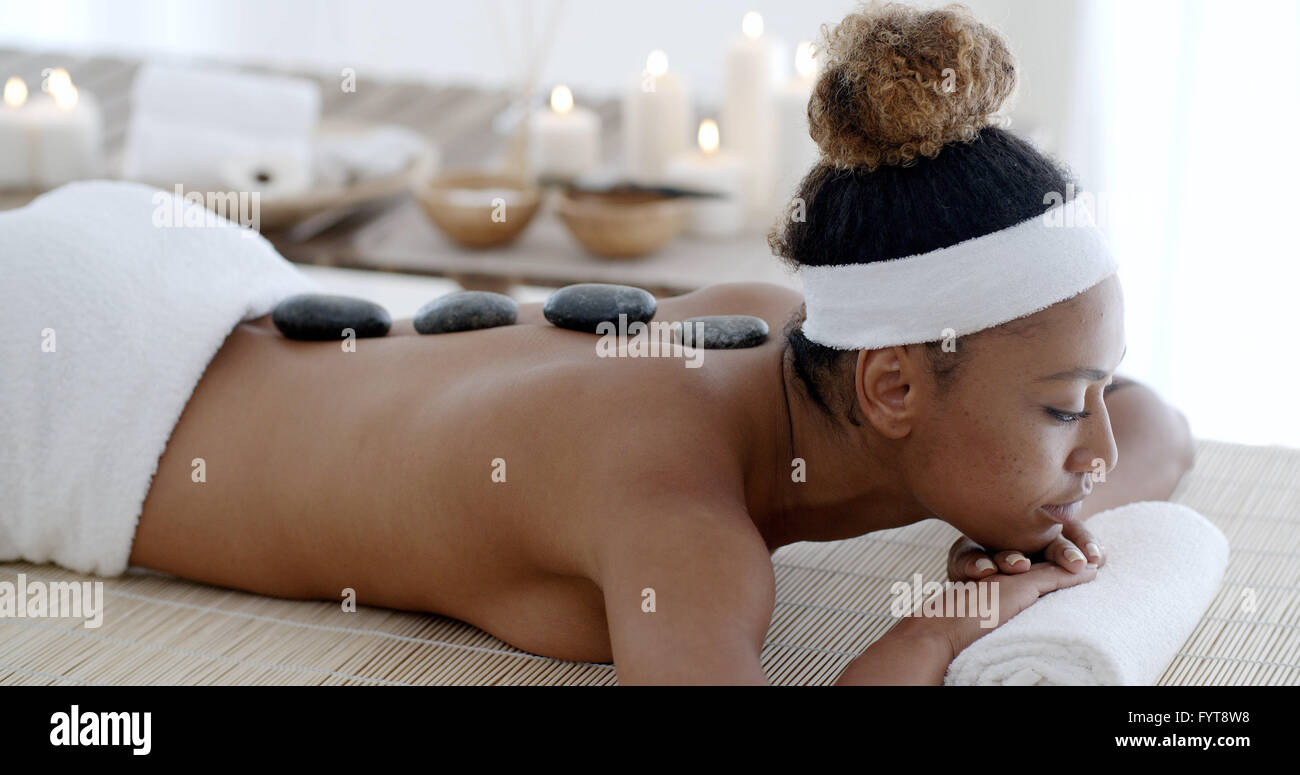 Frau mit Hot Stone Massage Stockfoto