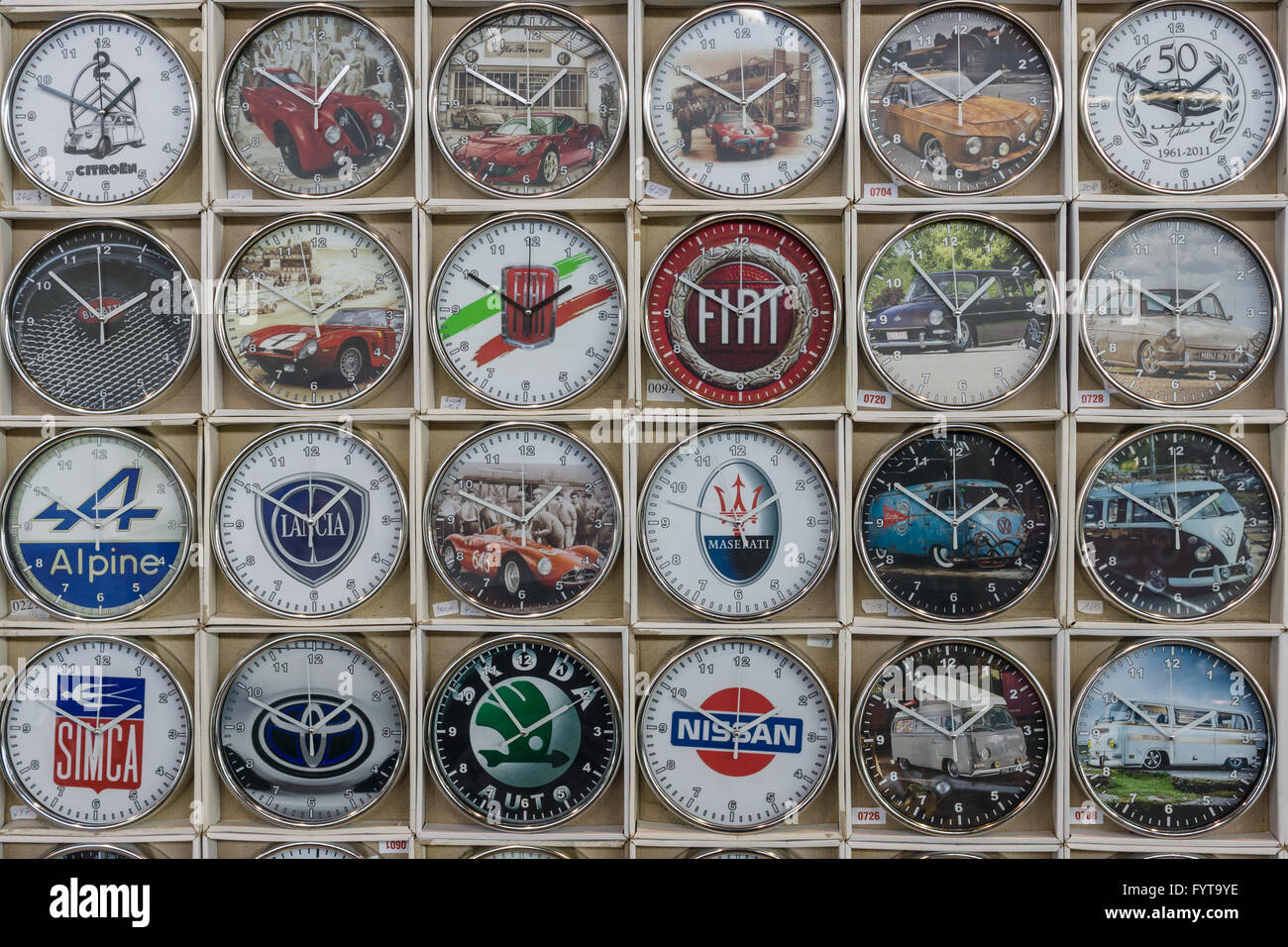 Im Hintergrund eine Wanduhr mit den Logos der bekannten Automobilunternehmen (retro und modern). Stockfoto