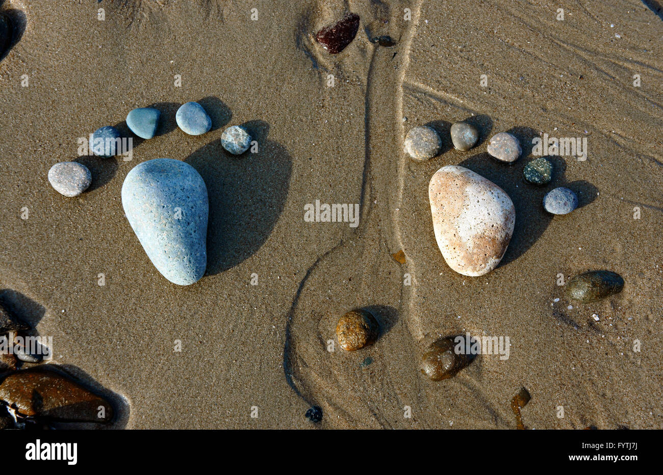 Gruppe des Fußes von Kies auf Sand Hintergrund, erstaunliches Konzept aus Stein mit gelber Farbe am Strand, tolle Kunst-Produkt Stockfoto