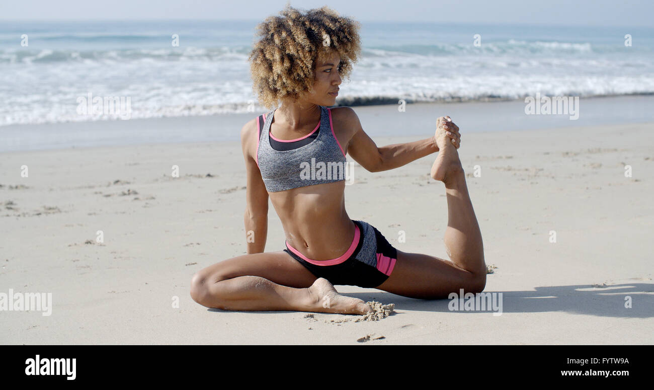 Frau In Yoga-Pose am Strand Stockfoto