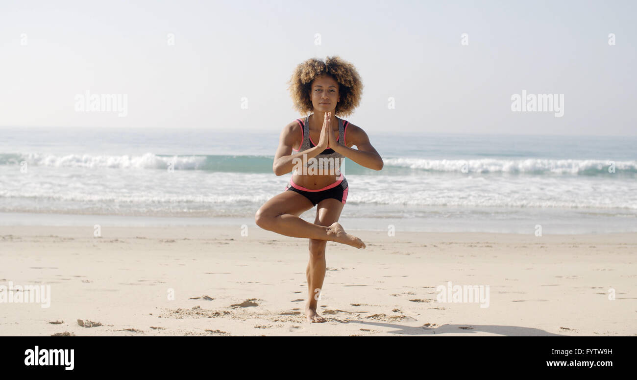 Frau tut Yoga am Strand Stockfoto