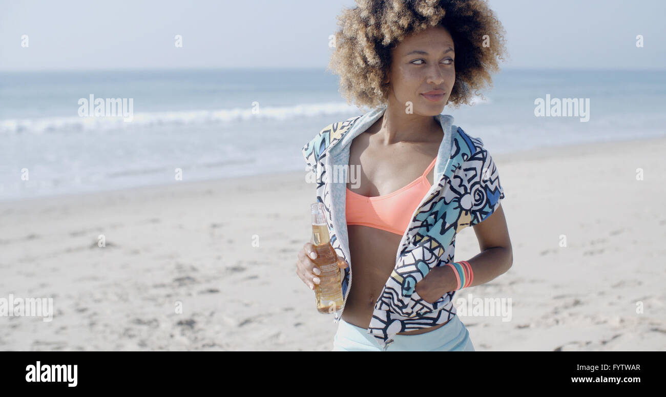 Frau mit Flasche gegen Sand Strand Stockfoto