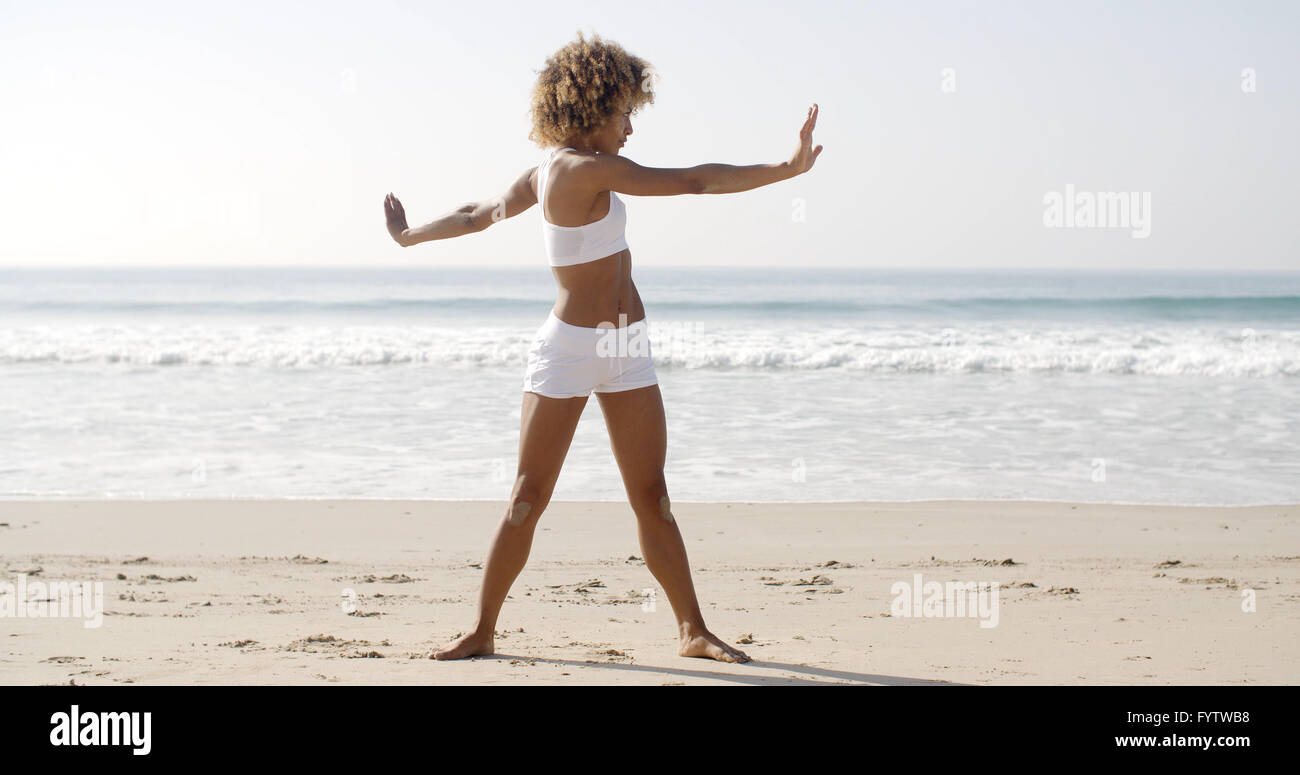 Frau Praktiken Yoga am Strand Stockfoto