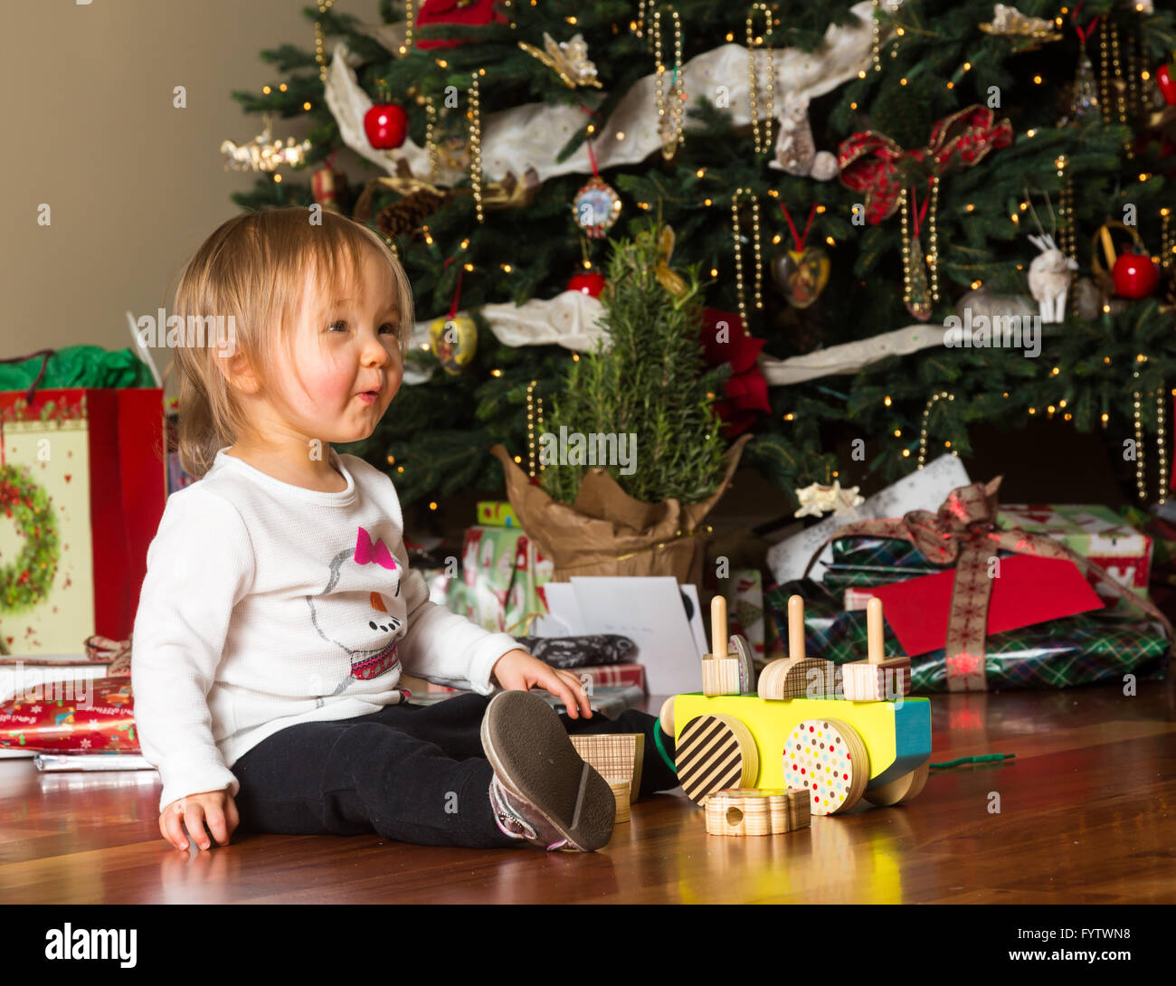 Junge kaukasische Mädchen öffnen präsentiert sich auf Weihnachten Stockfoto