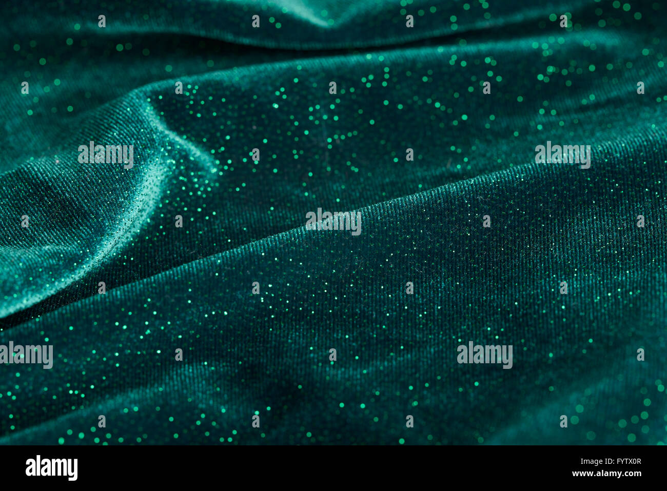 Eine abstrakte Aufnahme von gewellten grünen Stoff aus dem Kleid mit Glitzer drauf. Stockfoto