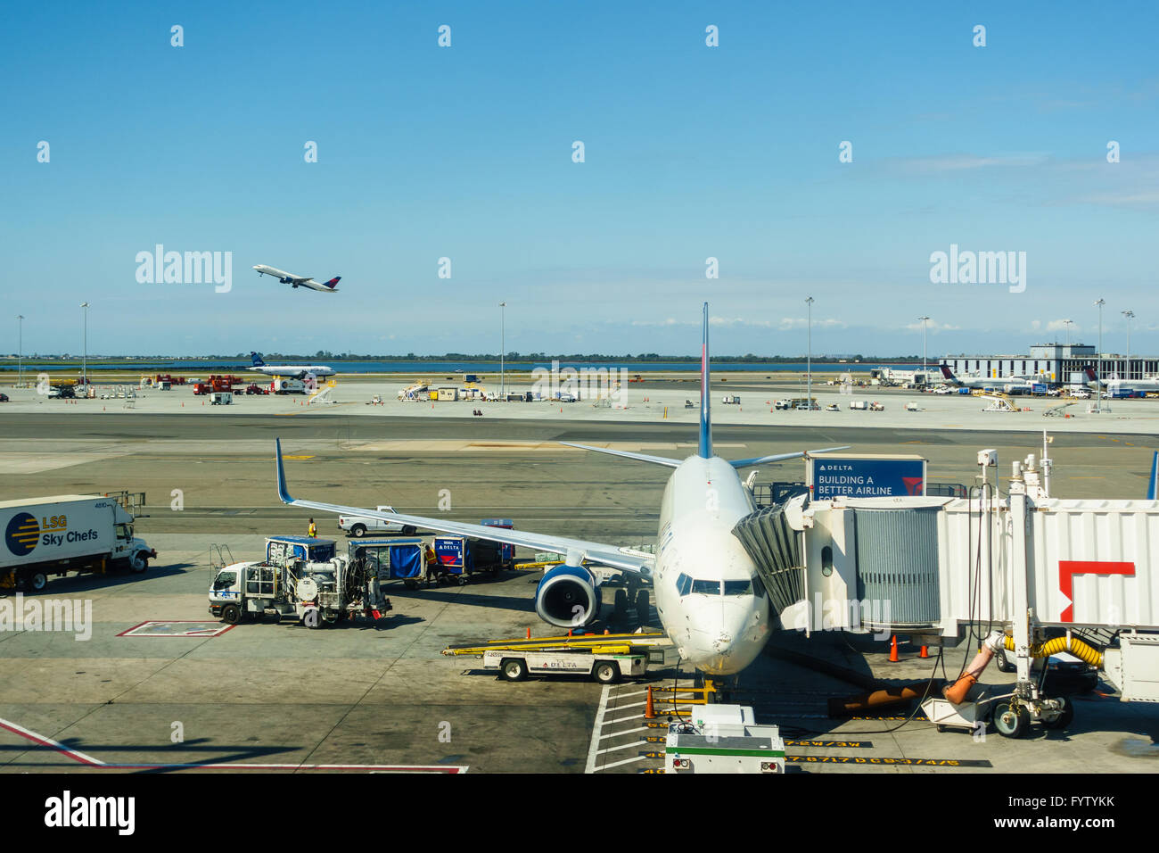 Flughafen New York JFK, Circa August 2015: A Delta Air Lines-Verkehrsflugzeug und ein weiteres Flugzeug im Hintergrund abheben. Stockfoto