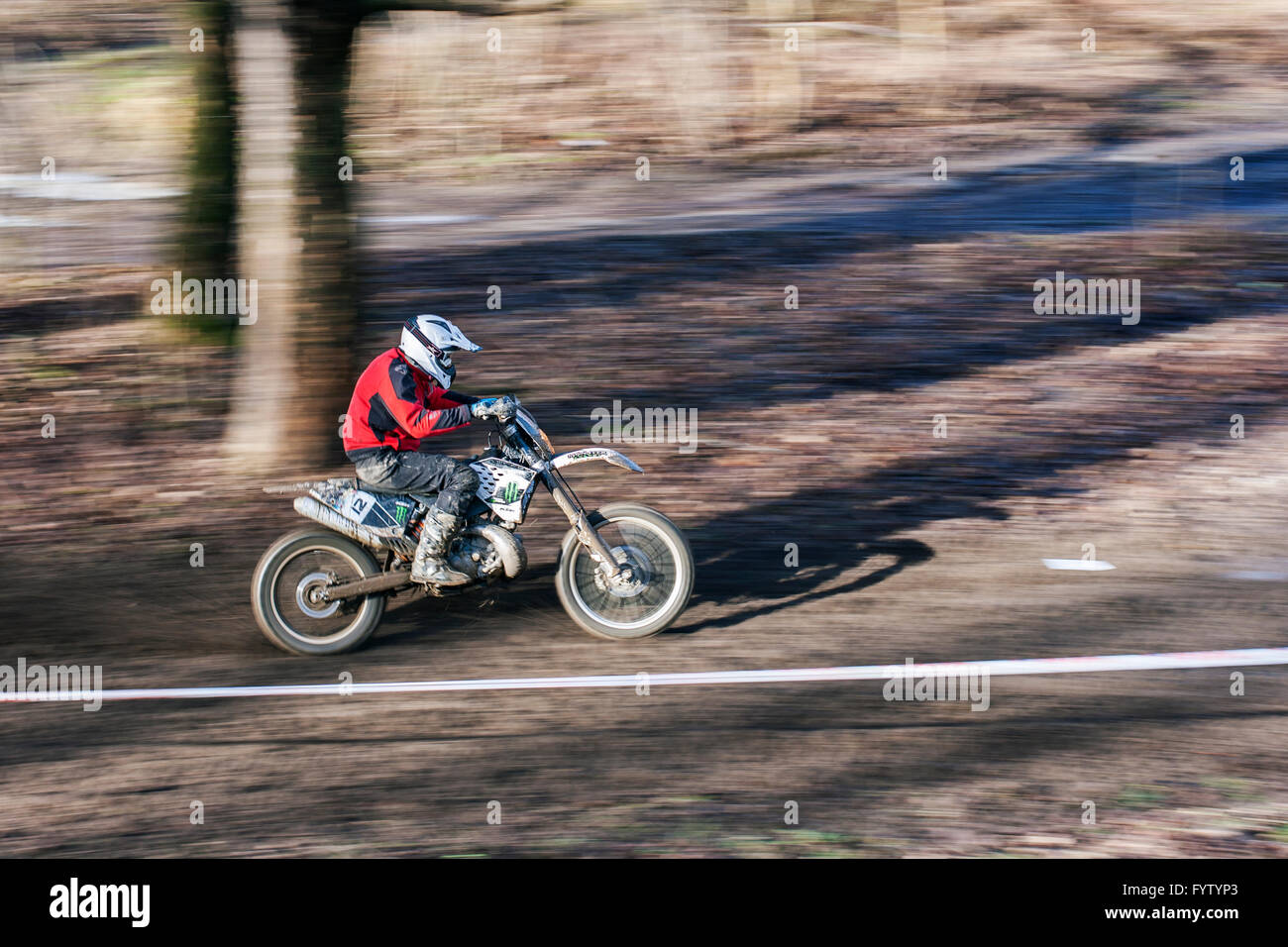 Enduro-Motocross-Fahrer fährt schnell durch den Wald Stockfoto