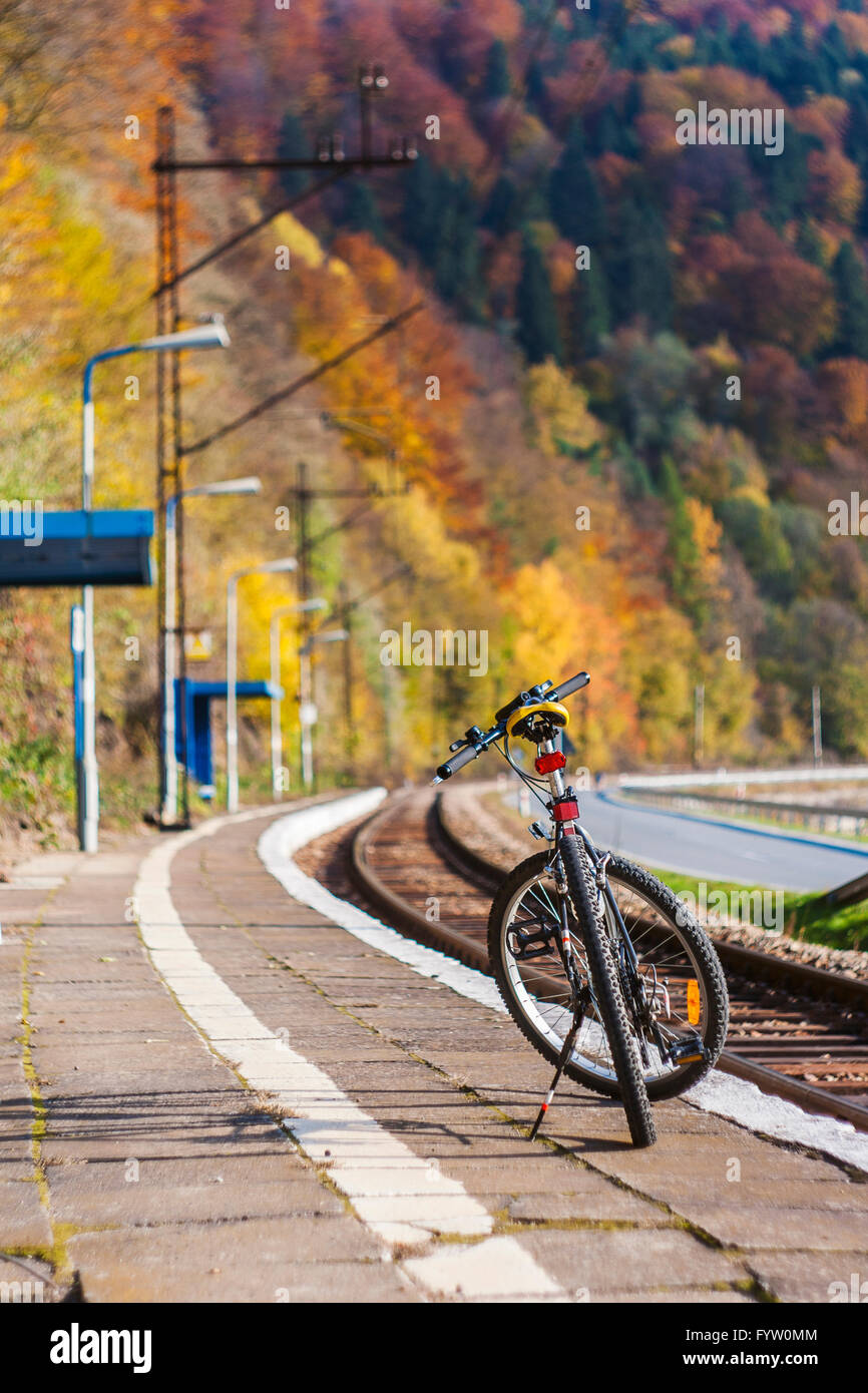 Fahrrad steht allein auf dem Bahnsteig unter den herbstlichen Wald in Wierchomla, Polen Stockfoto