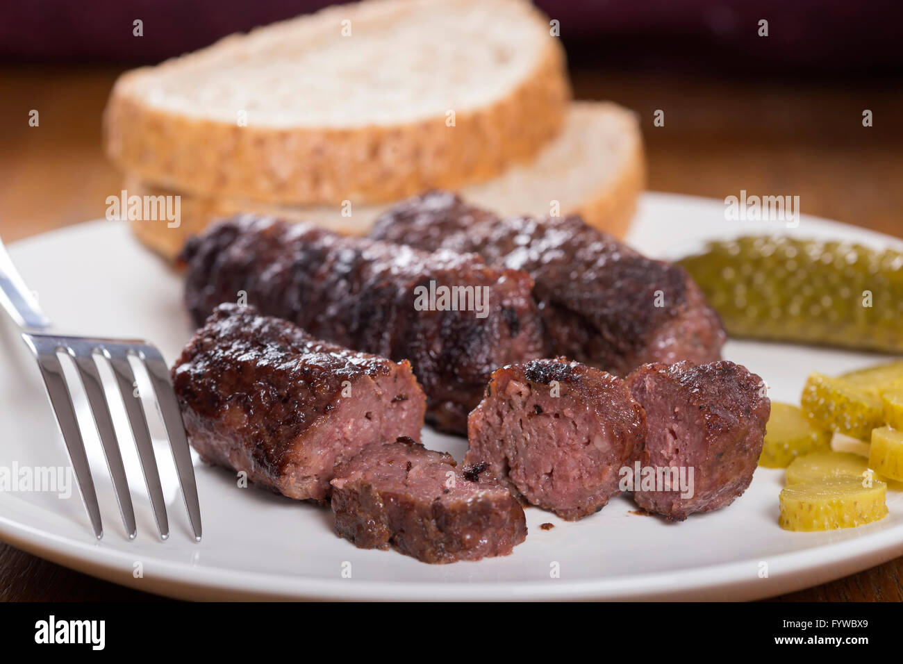 Traditionelles Essen "Mici" Würzige Frikadellen auf weißen Teller mit sauren Gurken Stockfoto