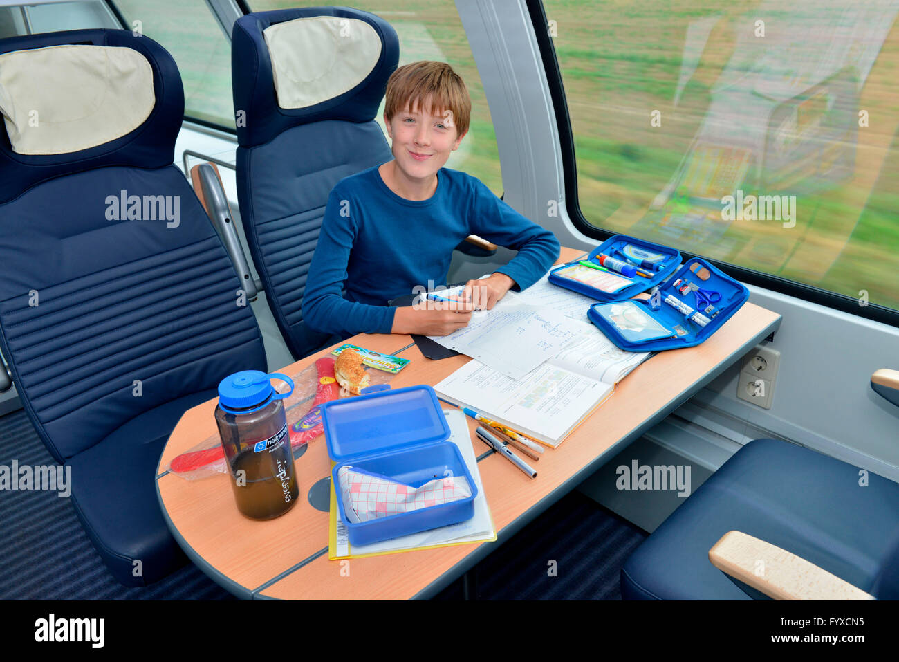 Junge im Zug, seine Hausaufgaben, Deutschland Stockfoto