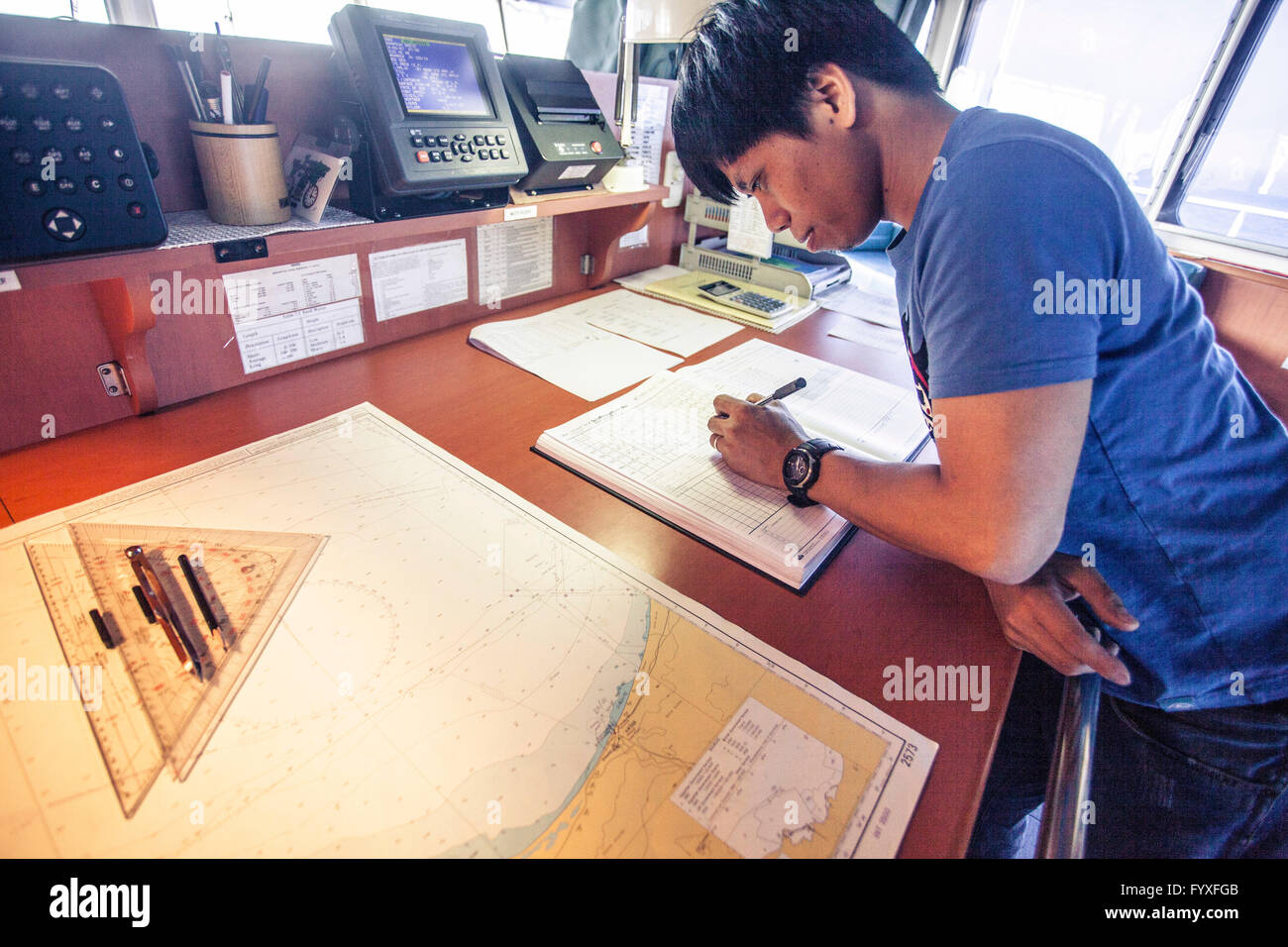 Offizier auf einem Containerschiff überprüft Karten und Karten, bevor er durch den Golf von Aden fährt. Stockfoto