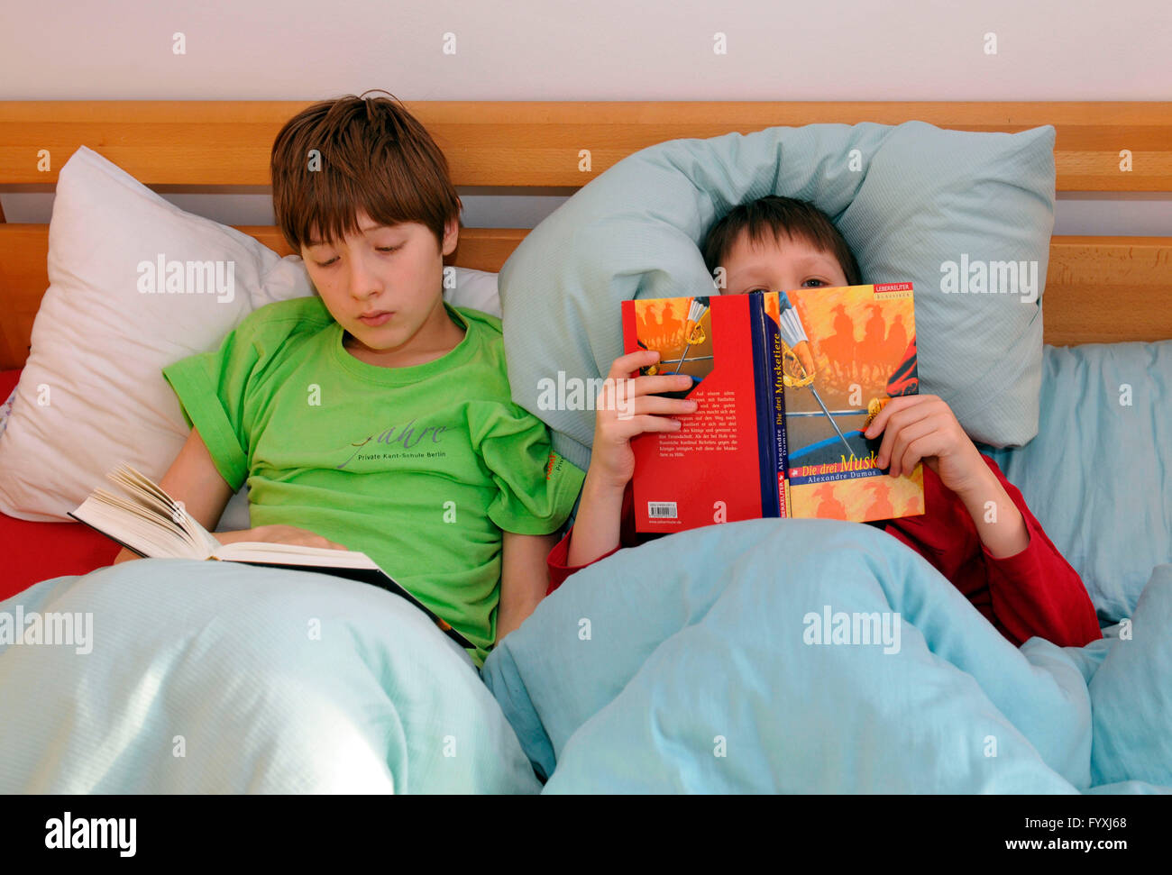 Kinder lesen Bücher im Bett Stockfoto