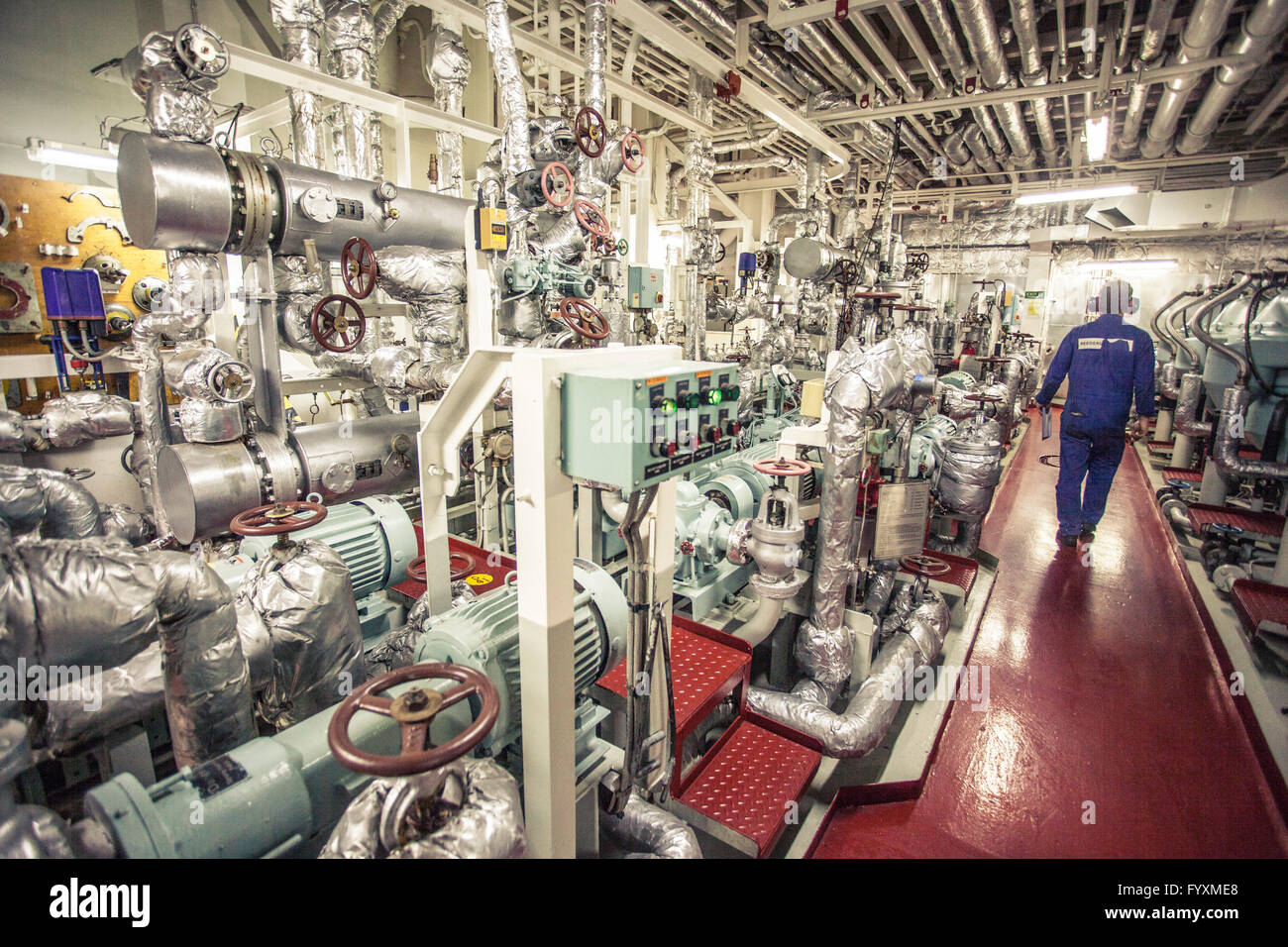 Chefingenieur eines Containerschiffes zu Fuß durch einen Raum mit Generatoren und Lebenserhaltungssysteme. Stockfoto
