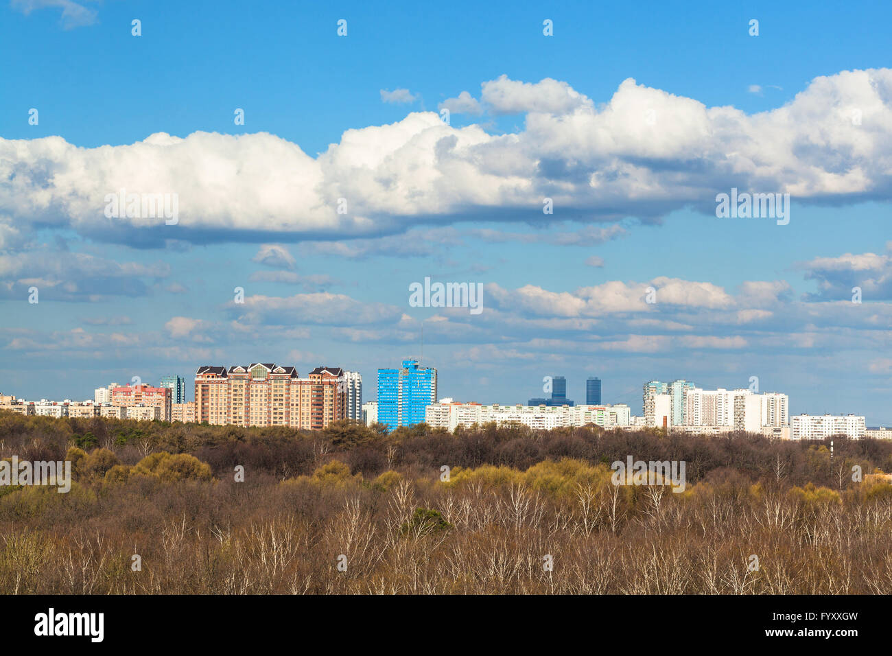 blauer Himmel mit weißen Wolken über Stadt und Wald im sonnigen Frühlingstag, Moskau, Russland Stockfoto