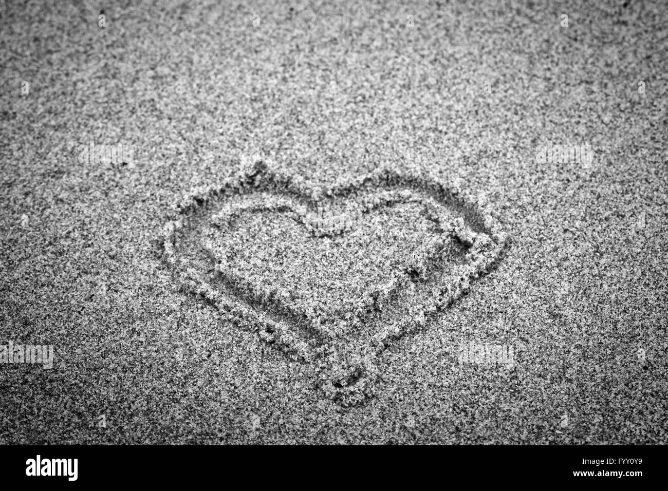 Herzform auf Sand. Romantische Stockfoto